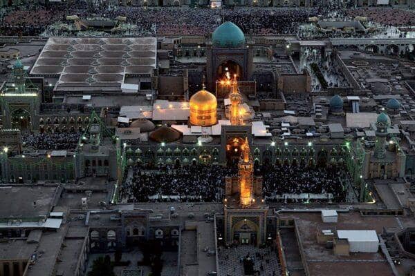 Aerial view of Imam Reza shrine courtyards filled with pilgrims, a golden dome shines, showcasing the spiritual heart during a virtual tour, supported by ETH.