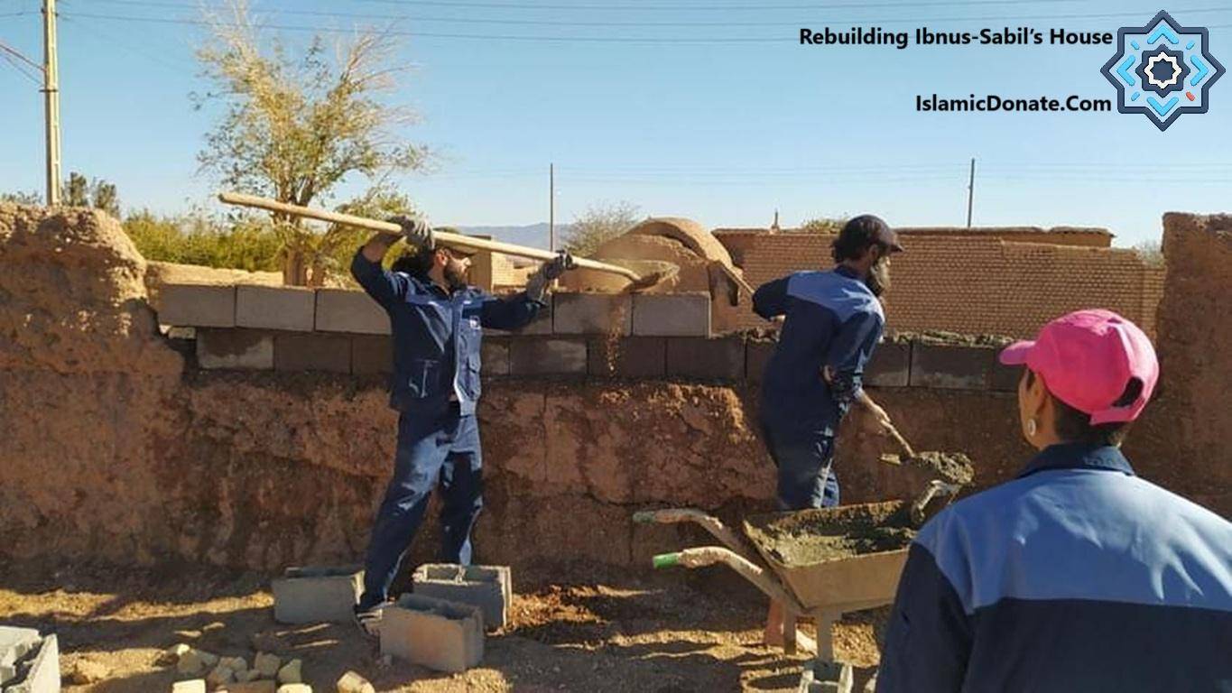 Workers rebuilding a house using blocks and mortar, symbolizing rebuilding homes for the displaced (Ibnus-Sabil) funded by crypto donations, possibly via USDT.
