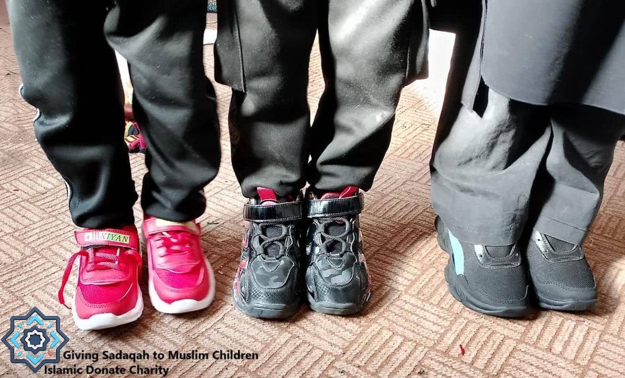 Close-up of children's feet wearing new shoes, signifying clothing provisions funded by crypto donations. Islamic relief for Muslim children aided by USDC.