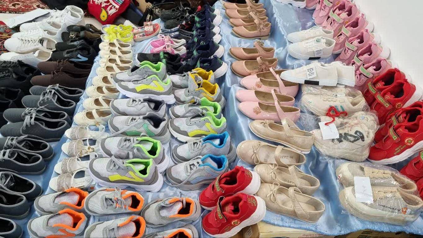 Rows of children's shoes for donation, including sneakers and ballet flats, a tangible representation of crypto Khums being channeled to aid needy children.