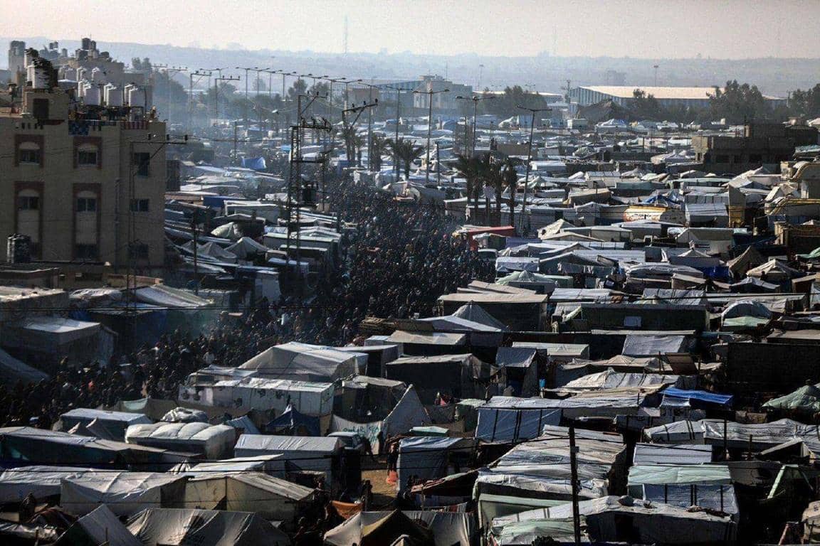 View of a crowded refugee camp with tents and shelters, showing signs of hardship. Support healthcare for displaced families with crypto donations, including ETH.
