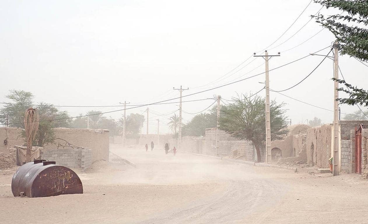 Dusty village street with people walking, symbolizing the need for relief and aid supported by crypto donations like USDT.