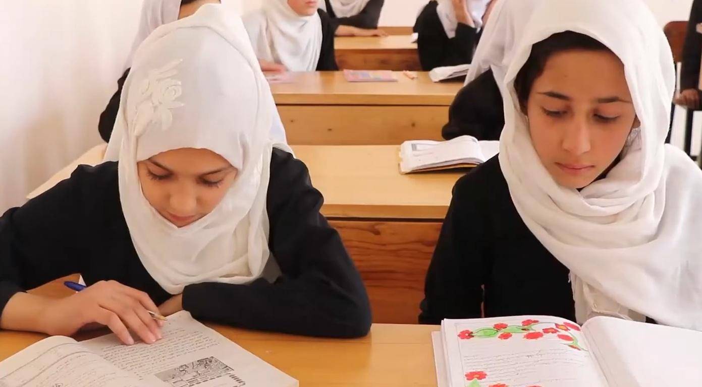 Young Muslim girls study in a classroom, supported by crypto Khums donations funding education for orphans.