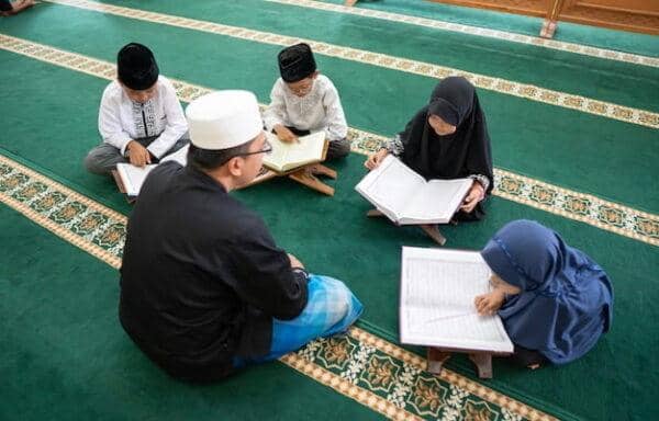 Children learning to read the Quran with an instructor, fostering education and economic opportunities through literacy, supported by ETH donations.