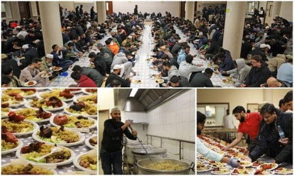 Community meals being served to a large group of people, including volunteers preparing food, supporting combatting social isolation with possible crypto donations.