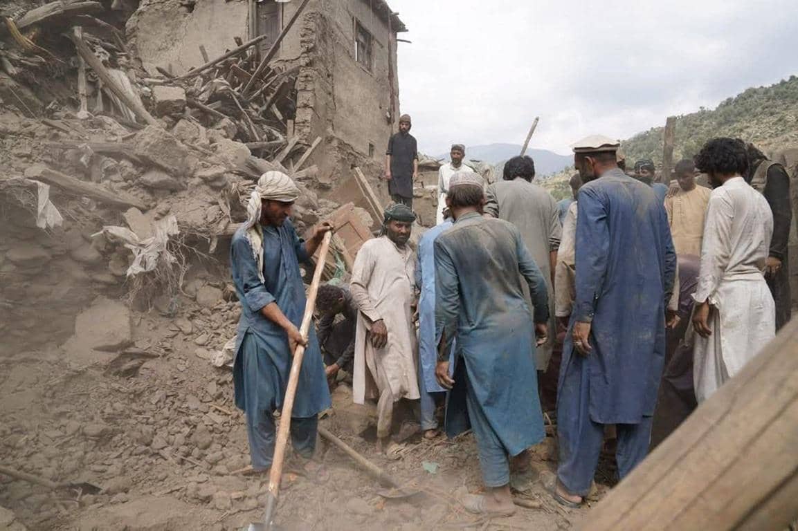 Men clearing rubble from earthquake-damaged buildings in Afghanistan, with aid supported by BTC donations.