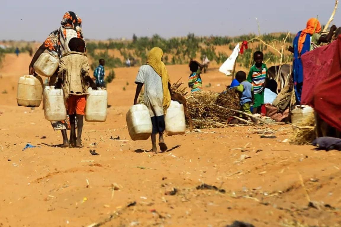 Children carrying water containers in a dry landscape, symbolizing the urgent need for aid in Sudan and South Sudan, with support facilitated by Bitcoin donations for clean water initiatives.