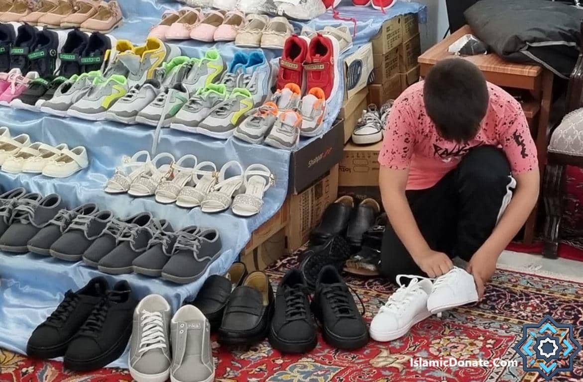 A child helps with shoe donation. Crypto donations for orphans and vulnerable children provide essential footwear for a brighter future.