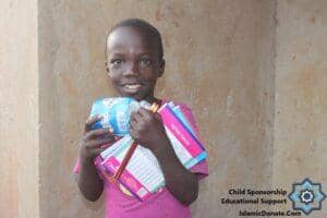 Smiling child holds school supplies, including notebooks and toiletries, representing educational support made possible by crypto donations via RLUSD.