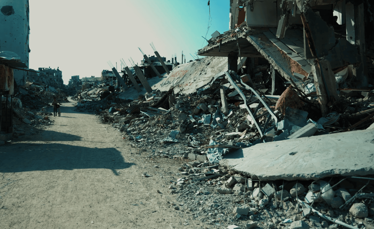 A child walks down a path through rubble and destroyed buildings, symbolizing the urgent need for orphan sponsorship via crypto donations, supported by XRP for good.
