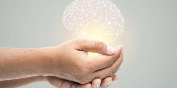 Hands cupped supporting a glowing outline of a brain, symbolizing mental health care and support. Donations accepted via ETH.