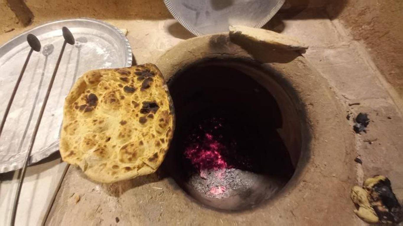 Freshly baked flatbread made in a traditional tandoor oven signifies aid for women in crisis, providing sustenance and dignity through crypto donations like ETH.