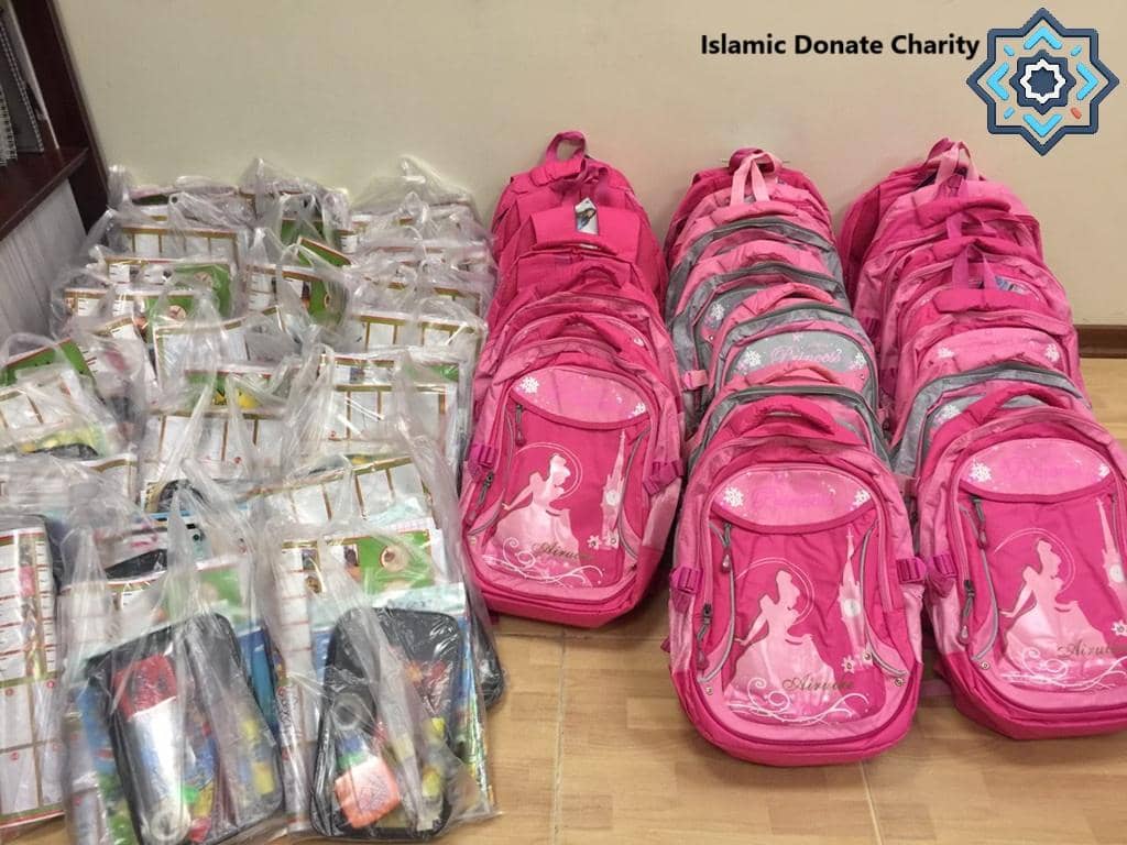 Rows of pink backpacks and school supply bags, depicting aid for children. This donation could be facilitated via crypto, supporting initiatives funded by Bitcoin.