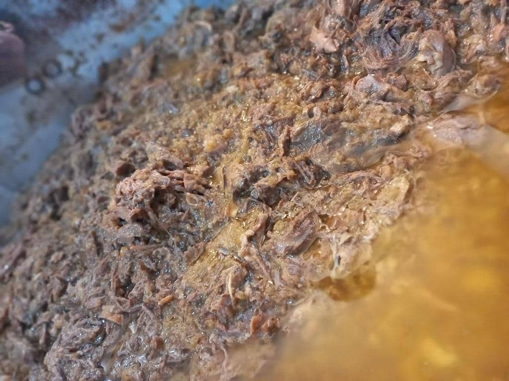 Close-up of slow-cooked meat stew, like Pakistani Nihari, prepared for a Muslim Aqiqah Qurbani donation, facilitated by cryptocurrency for newborn babies.