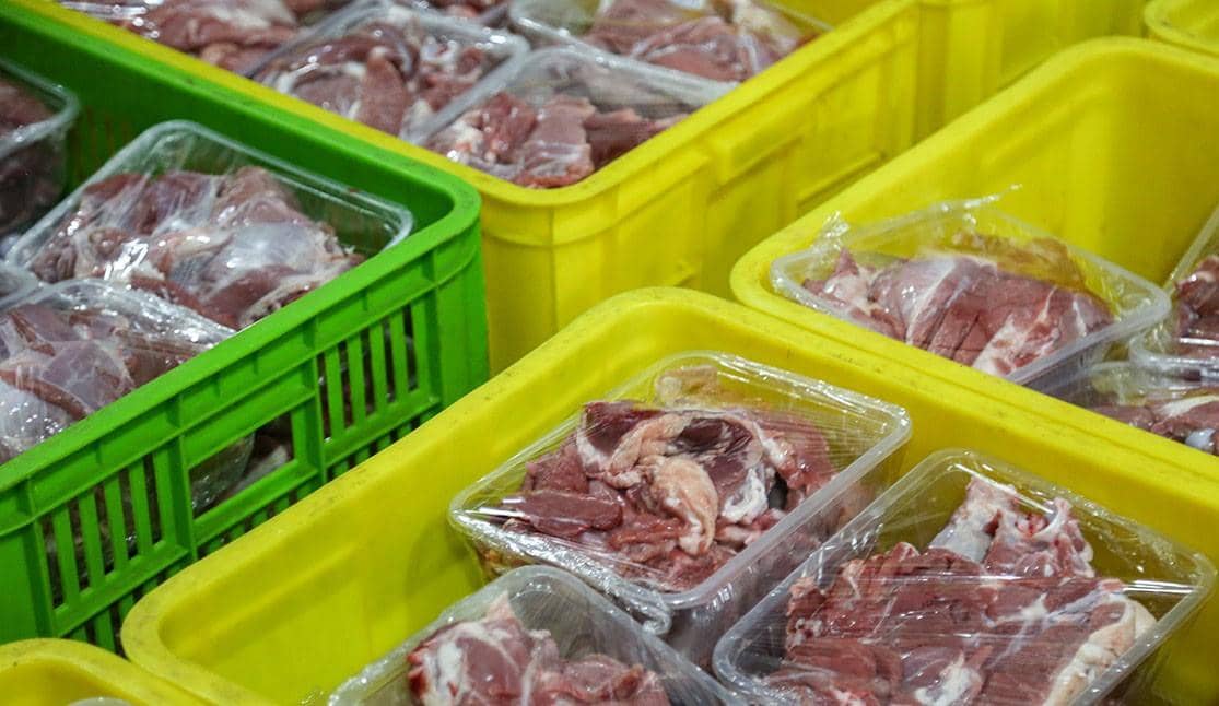 Eid al-Adha 2024 meat distribution featuring raw meat packages in crates, supported by ETH donations for humanitarian aid.