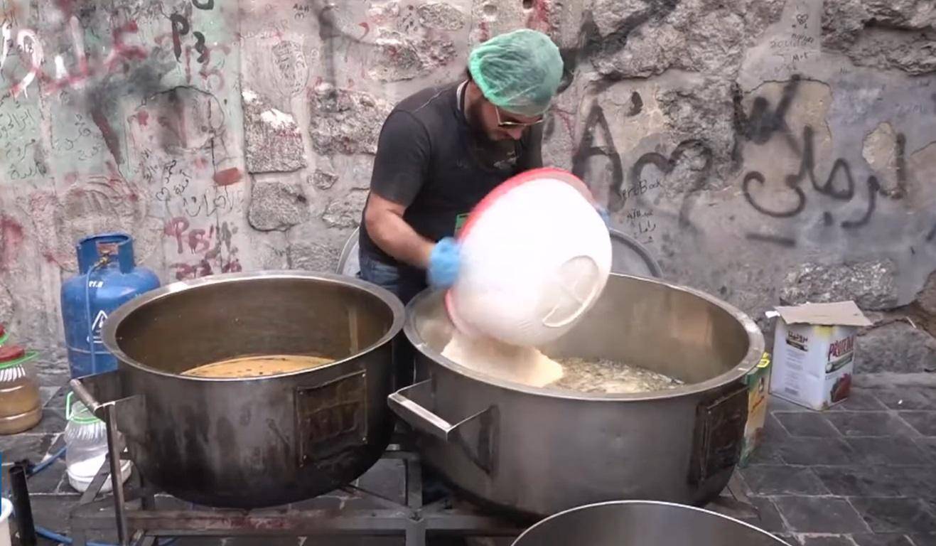 Man preparing food in large pots, distributing to the needy, with crypto donation support via SOL.