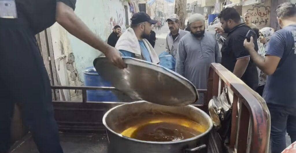 Aid in Palestine efforts serving food from a large pot, with volunteers preparing distribution supported by crypto via XRP.