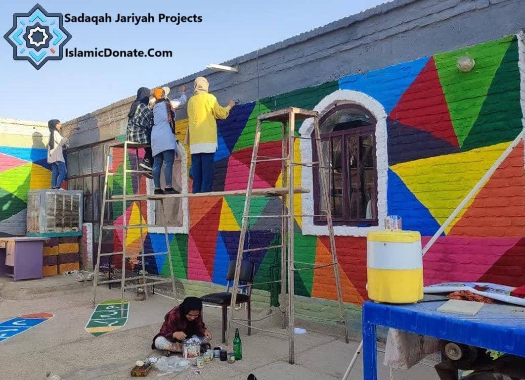 Sadaqah Jariyah Projects volunteers painting a colorful mural, creating a legacy of giving through crypto donations like RLUSD for community betterment.