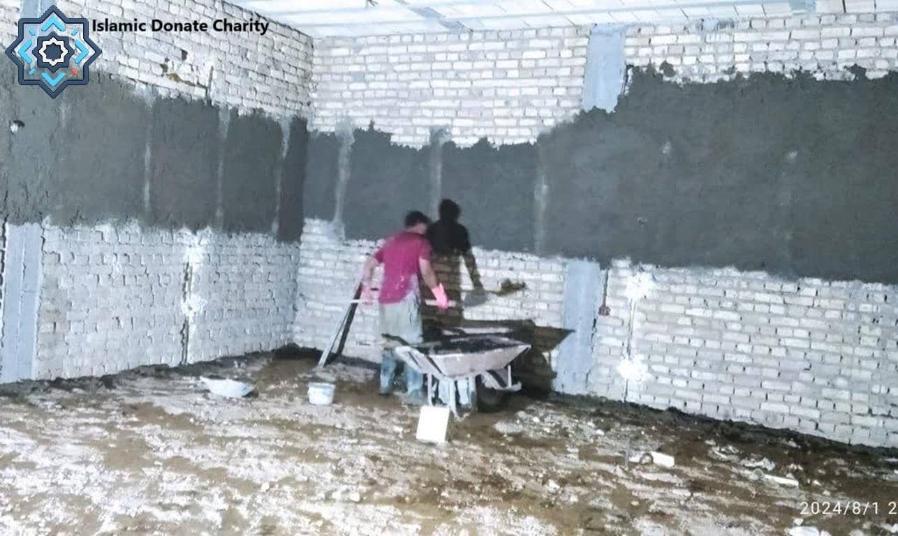 Sadaqah Jariyah construction site with workers applying plaster; donation for religious infrastructure projects funded by crypto like Bitcoin.