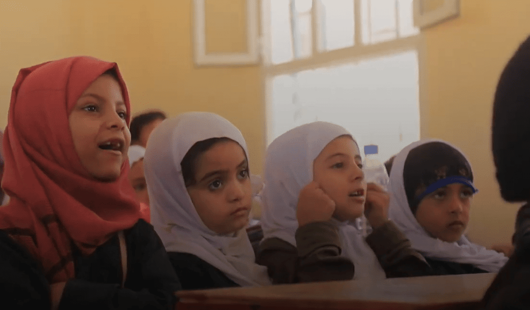 Young Yemeni schoolgirls in hijabs listen intently in a classroom, their education supported by crypto donations enabling access to laptops and the internet.