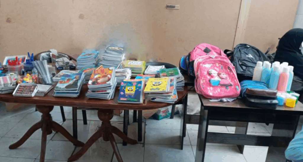 Back to School Report 2024: Piles of notebooks, pencils, and school supplies including backpacks and bottles of sanitizer, ready for distribution to sponsored orphans, made possible by crypto donations like BTC, fostering education and potential.