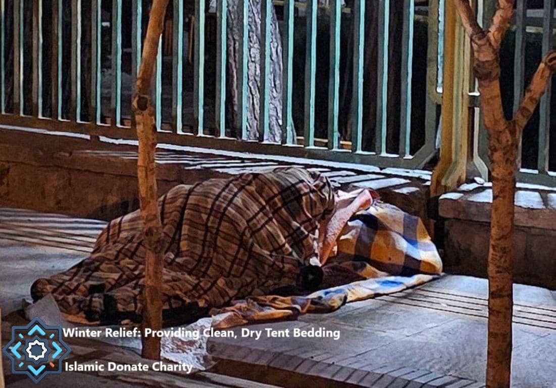 Person sleeping on the ground wrapped in blankets. Winter relief crypto donations provide warm bedding for vulnerable families. Donation via BTC.