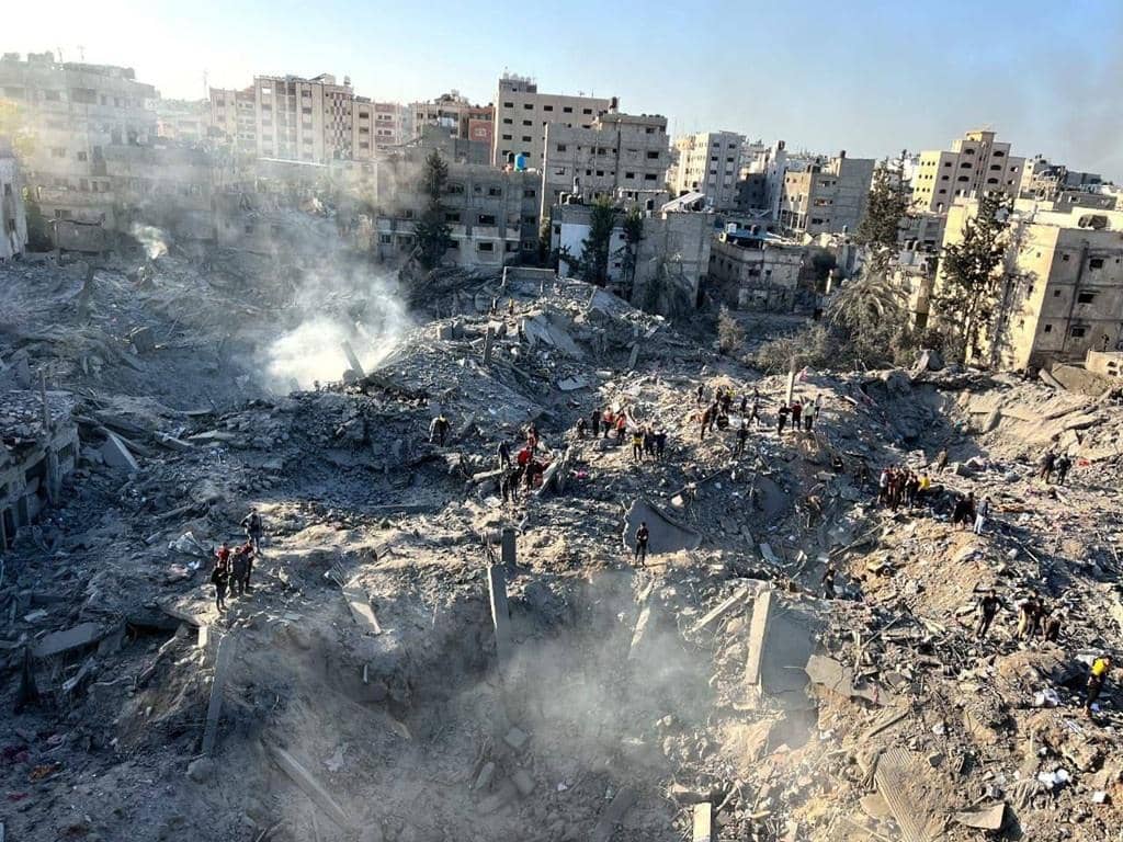 Rescue workers search through rubble of destroyed buildings in Gaza, aided by crypto donations.