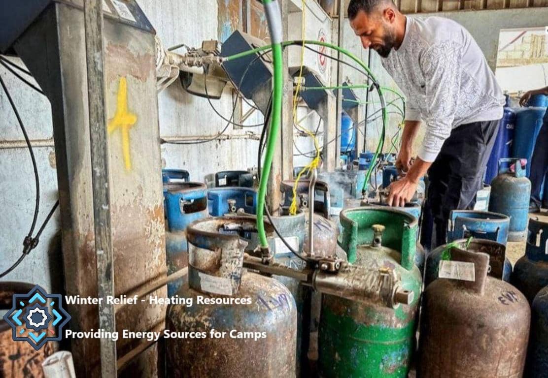Heating resources for winter relief in camps, providing energy sources. A man is connecting gas cylinders with hoses, possibly part of a distribution process for aid in conflict zones. Your crypto donation with USDT supports these vital efforts.