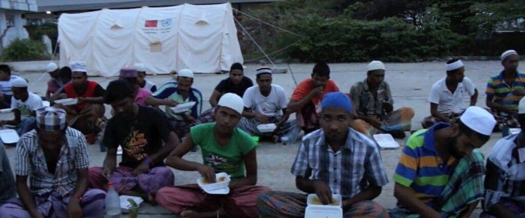 Muslims receiving Iftar meals from an Islamic charity, supported by crypto donations like LTC, during Ramadan.