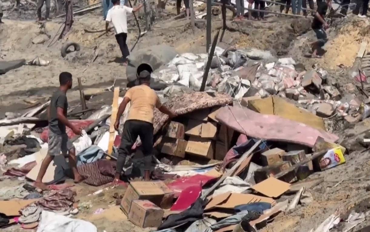 Tattered mattresses and boxes are sorted through piles of debris by aid workers, suggesting urgent relief efforts for war-torn Yemen, supported by crypto donations via XRP.
