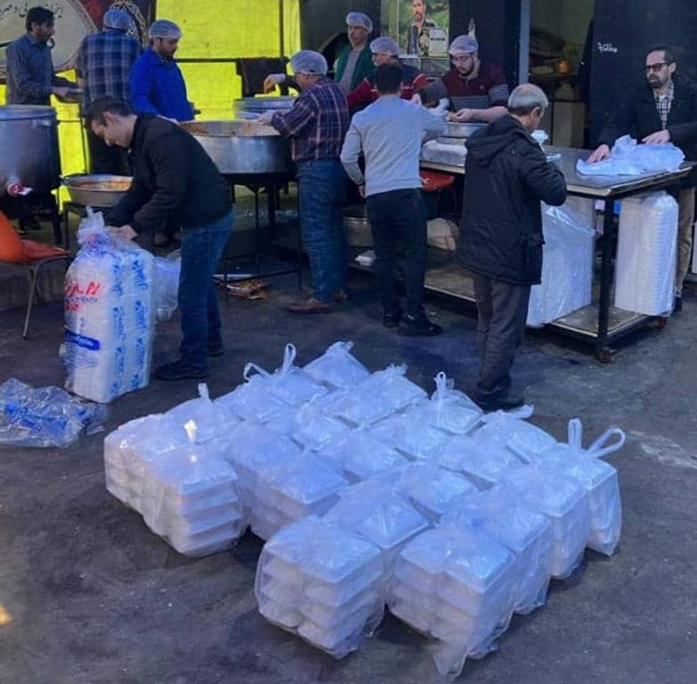 Volunteers in food distribution preparing meals for the needy during Ramadan, with crypto aided zakat support, likely using Bitcoin for donations to aid the Muslim Ummah.