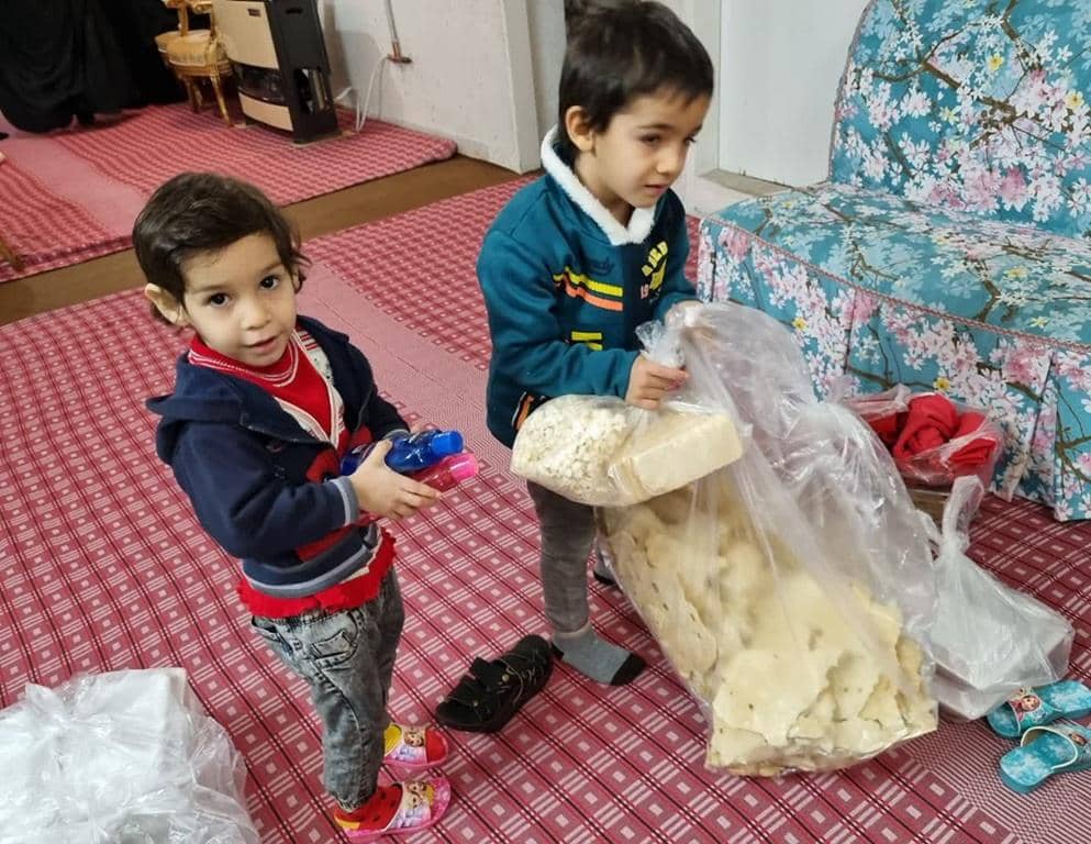Two children holding bags of bread, symbolizing hope and sustenance provided through crypto donations like USDT to Palestinians in Gaza.