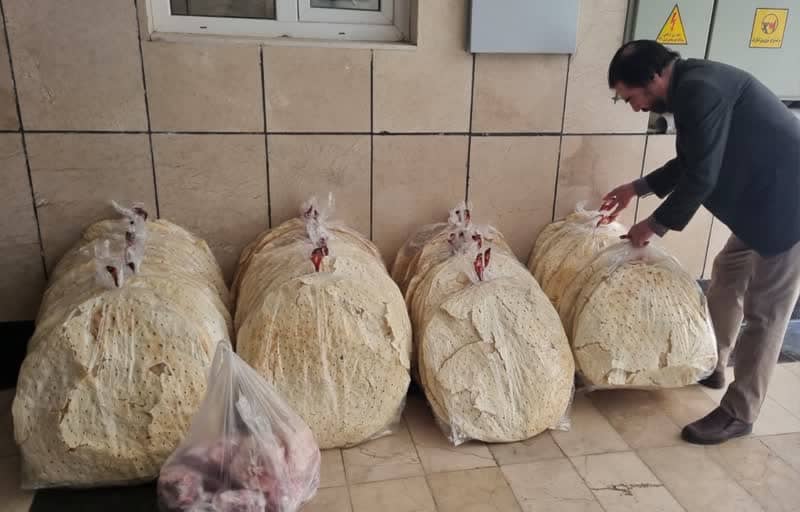 Man arranging large flatbread packages, symbolizing direct crypto donations for providing food aid to vulnerable communities.
