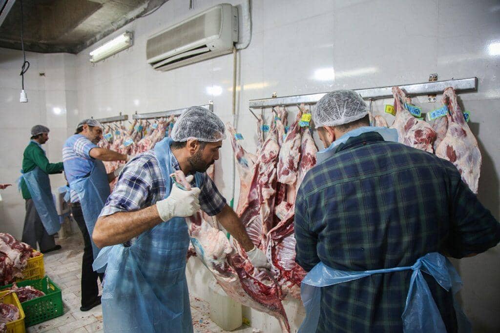 Men in a clean facility preparing sacrificial meat for Eid al-Adha distribution, enabled by crypto donations like BTC, supporting Qurbani missions in Africa and Asia.