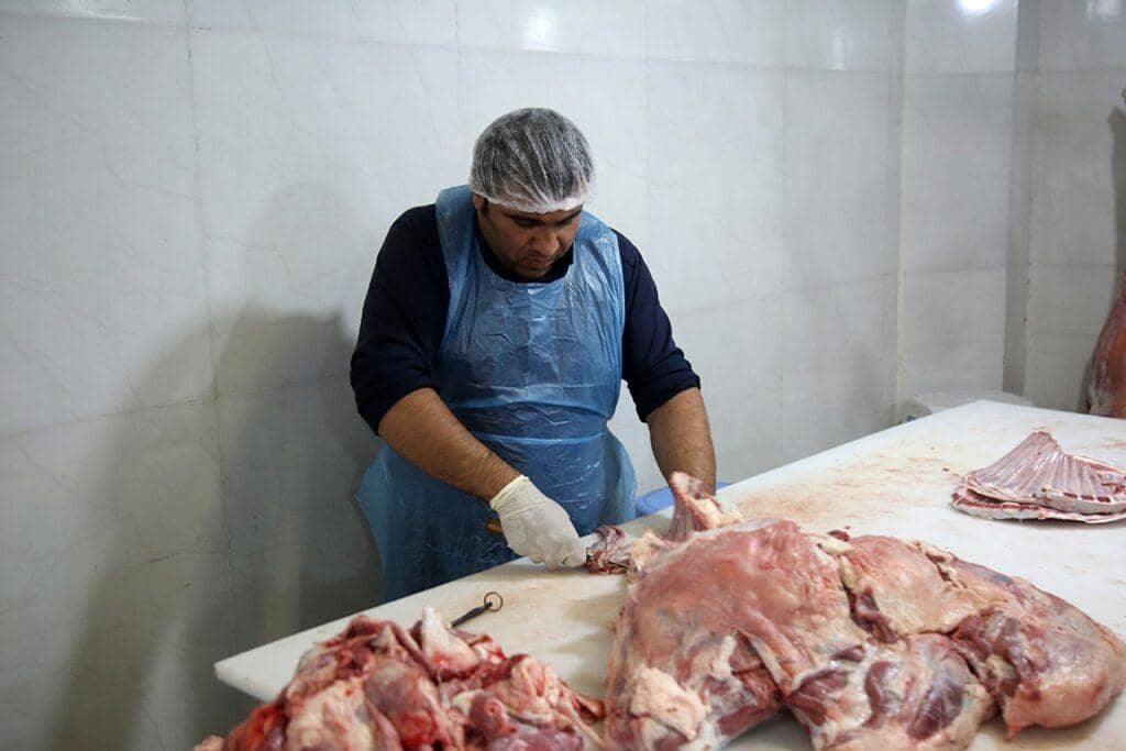 Butcher preparing sacrificial Qurbani meat for distribution across Africa and Asia, aided by crypto donations. ETH coin donations facilitated feeding the needy.