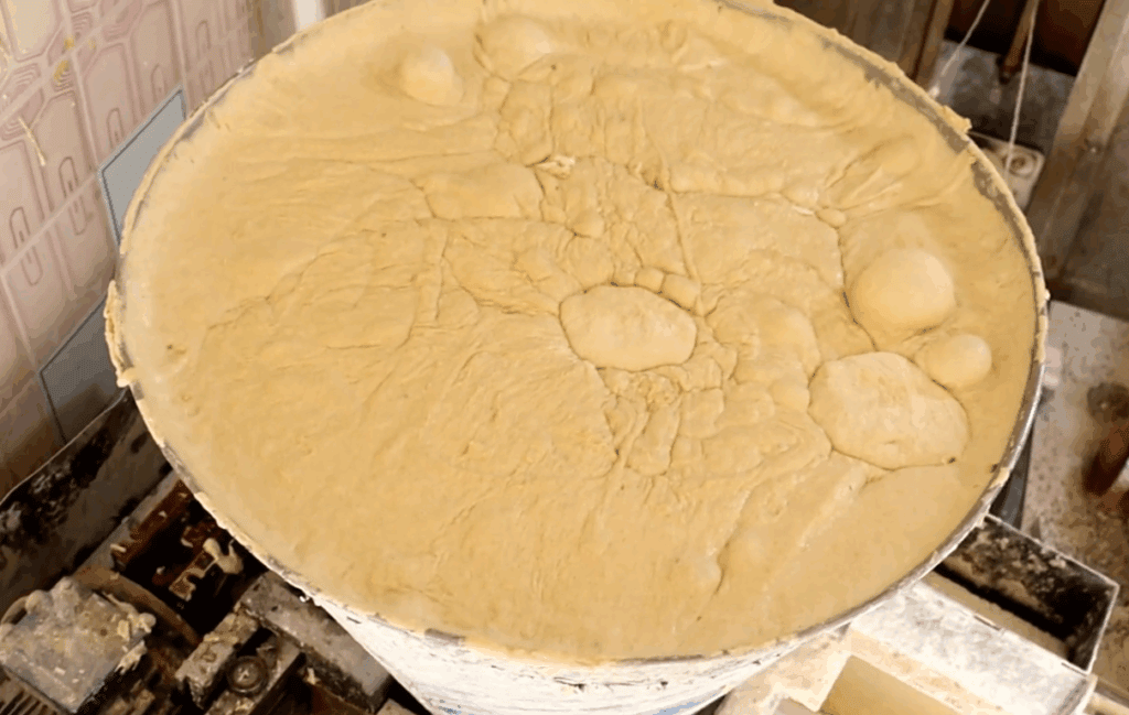 Large batch of dough being prepared for baking, representing humanitarian aid delivery to Gaza children, supported by crypto donations via USDT.