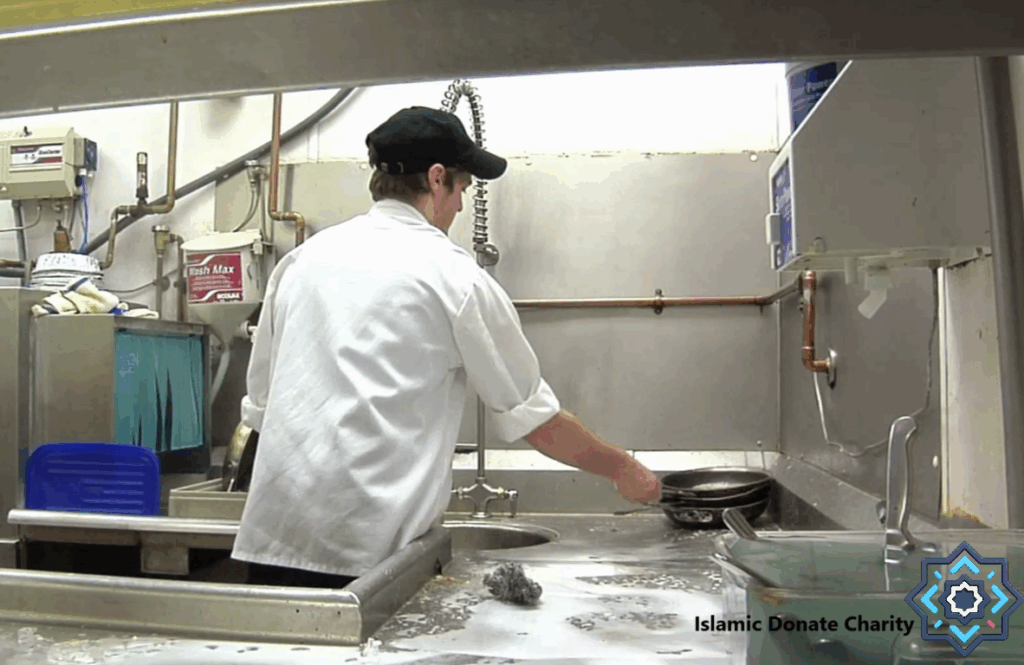 Volunteer washing dishes in a charity kitchen, supporting food aid projects with crypto donations like ETH.