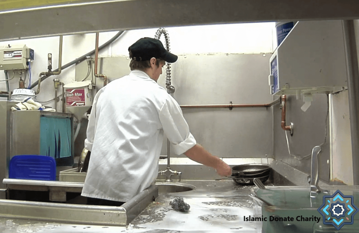 Volunteer washing dishes in a charity kitchen, supporting food aid projects with crypto donations like ETH.