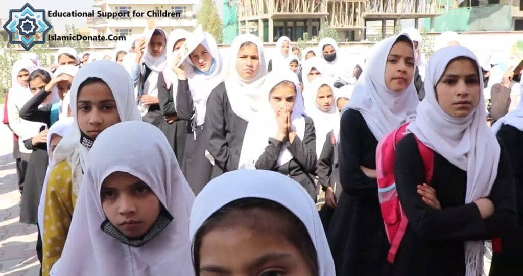 Children in Muslim attire lining up, some with headscarves, representing educational support for youth in Asia and Africa funded by crypto donations like BTC.