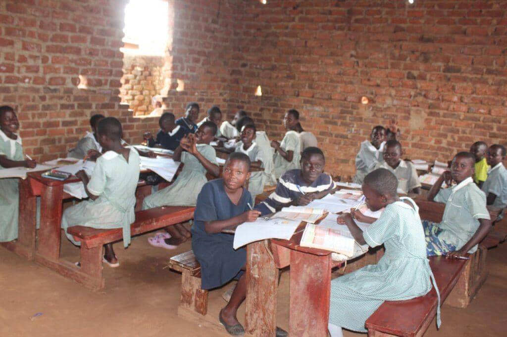 Children in a classroom, engaged in learning, benefit from educational support and crypto donations, fostering literacy and digital skills with USDT.