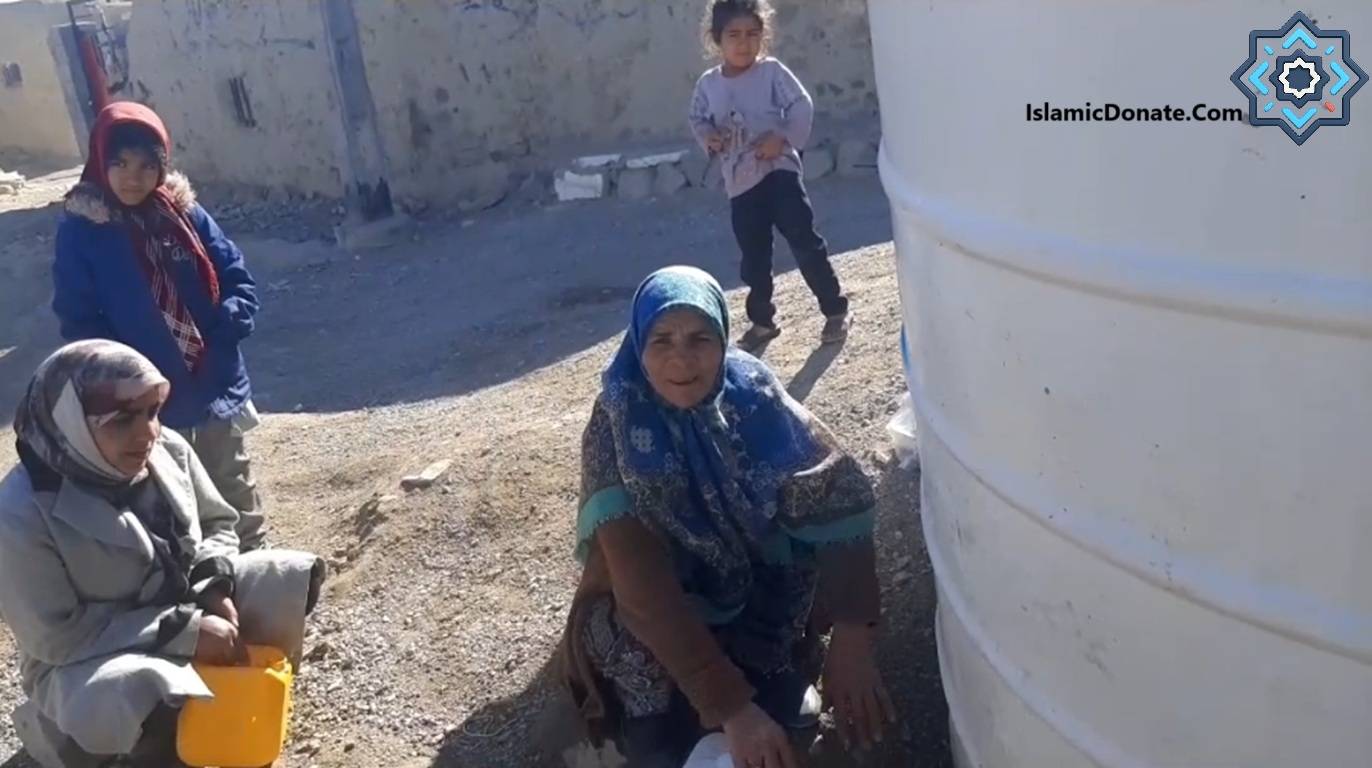 Children and women collecting water from a large tank, illustrating the impact of crypto donations for clean water initiatives.
