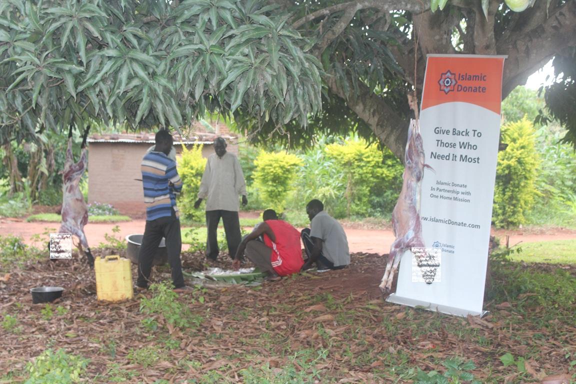 Men preparing meat from a sacrificed animal beside an Islamic Donate banner, supporting crypto Qurbani donations like SOL aid.