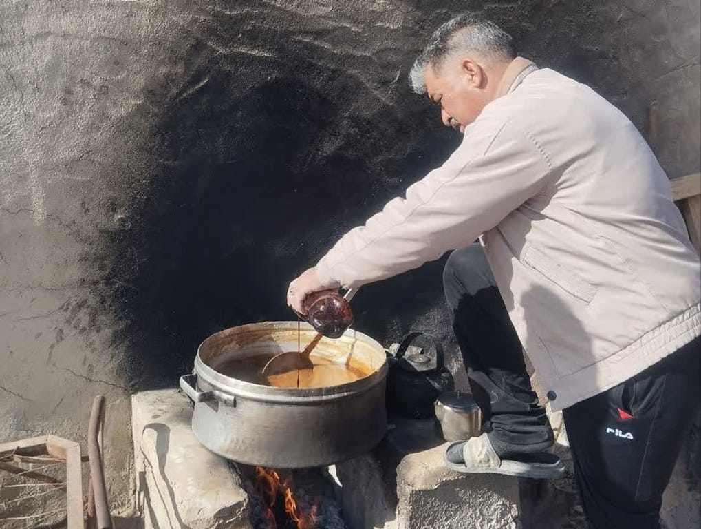 Help Rafah and Gaza relief efforts with TRX. A man cooks food aid in a large pot over an open fire to feed families.