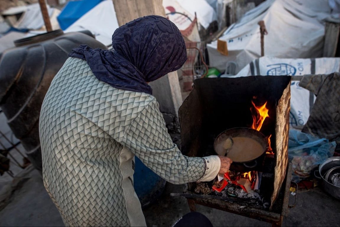 Help Rafah women cooking over fire in Gaza relief camp. Support emergency food aid with SOL cryptocurrency and donations.