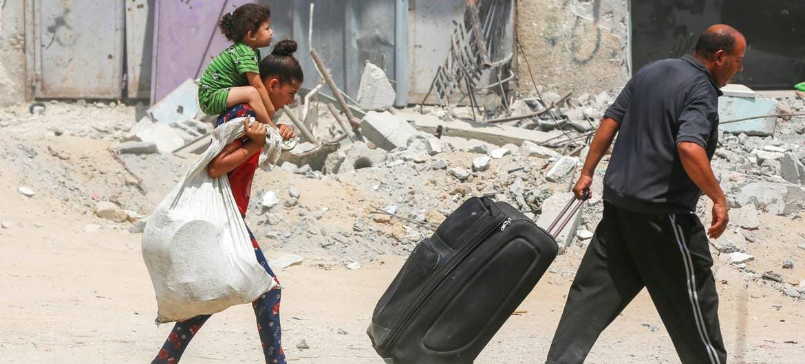 Displaced Gazans carry belongings through rubble, with crypto donations via USDT providing essential aid to those in need for water, food, and shelter.