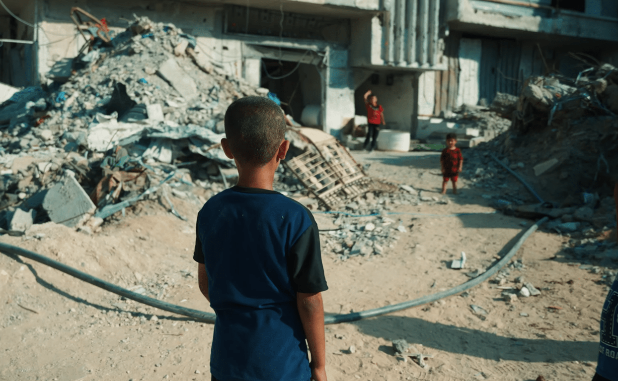 Child looks at rubble after destruction. Donation of crypto like Ripple provides aid for families.