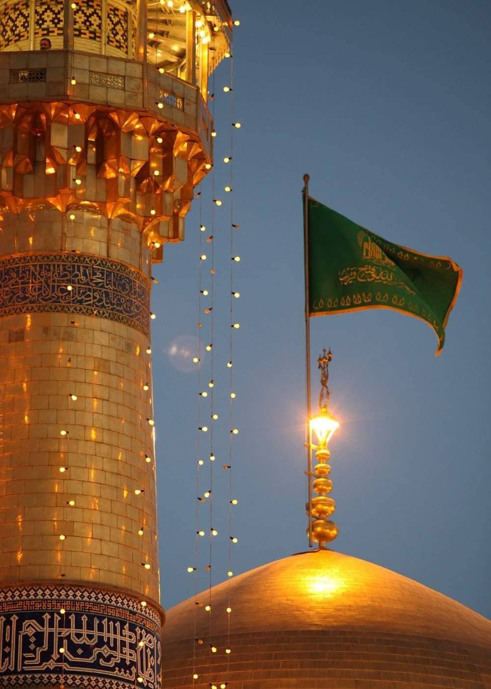 Golden minaret and dome of a mosque with a green flag. Lights hang between the structures, suggesting festive or ceremonial decorations. This image implies crypto-supported Islamic relief and charitable giving, processed via ETH.