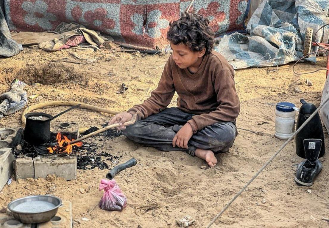 Zakat online with cryptocurrency help needy boy cooking on small fire. Send TRX relief to displaced families.
