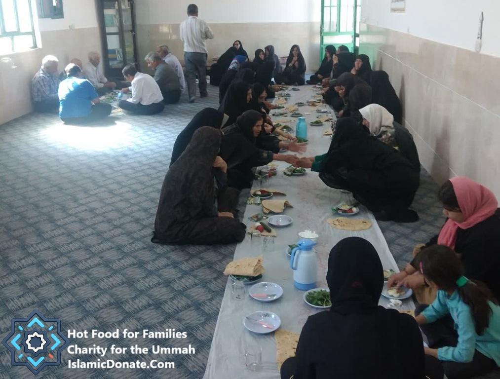 Group of people, some men and women, sitting on the floor gathered around a long table for a meal. This event is supported by crypto donations, providing hot meals for families. Key elements: daily charity, relief for the needy, sustainable livelihoods, hot meals, Islamic relief, aid provision, with support via ETH.