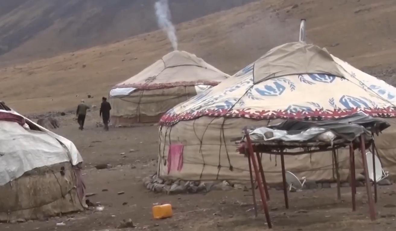 Yurts in a mountainous region, with smoke emanating from one, suggesting community support and education initiatives, possibly enabled by crypto donations like XRP.